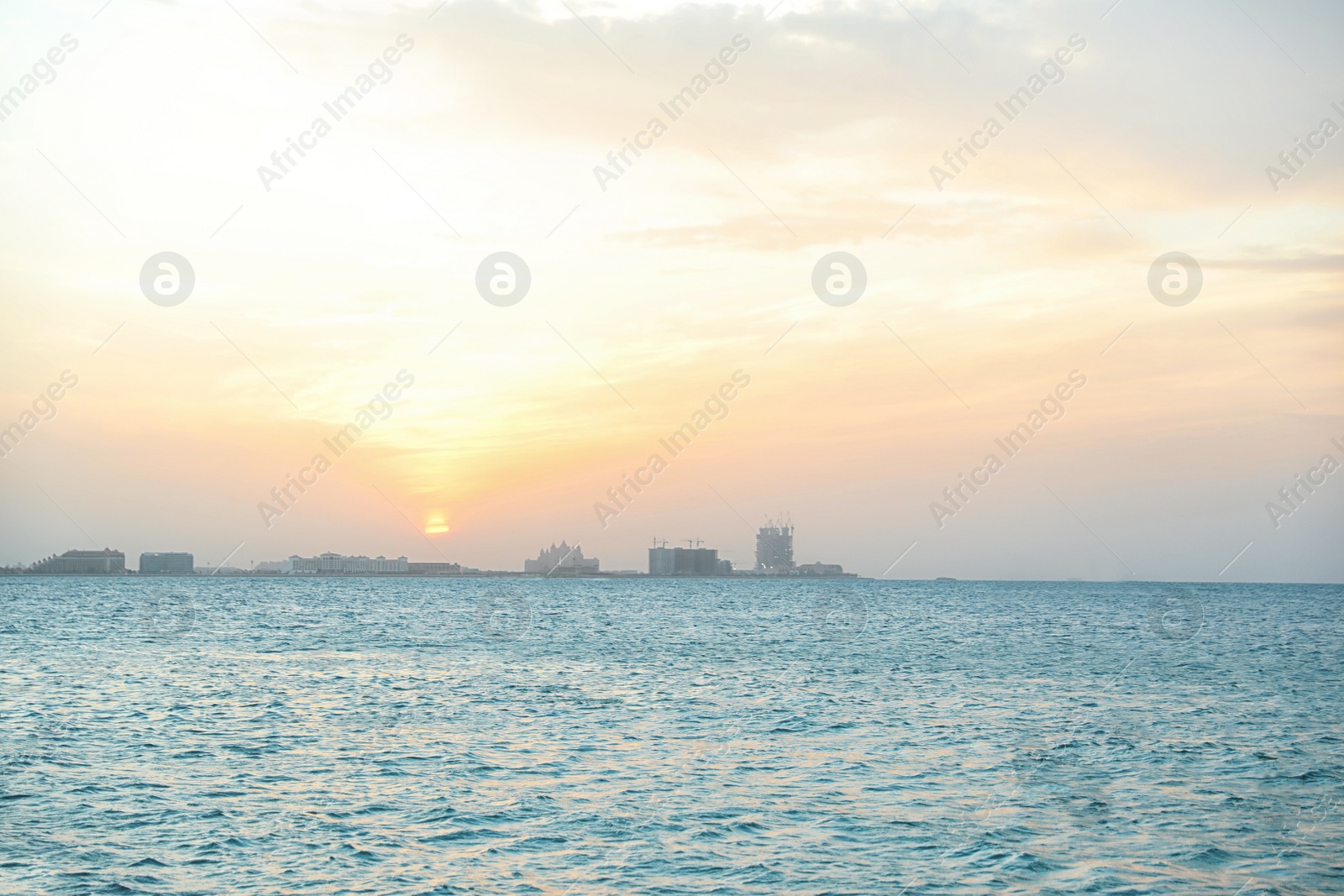 Photo of Beautiful view of sea, distant city on shore and amazing sunset sky