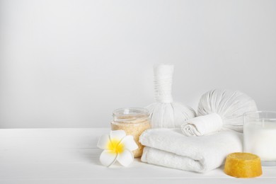 Photo of Spa composition with care products on white wooden table. Space for text