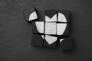 Photo of Heart drawn on black cubes, flat lay. Composition symbolizing problems in relationship