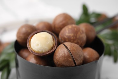 Photo of Tasty organic Macadamia nuts in small saucepan, closeup