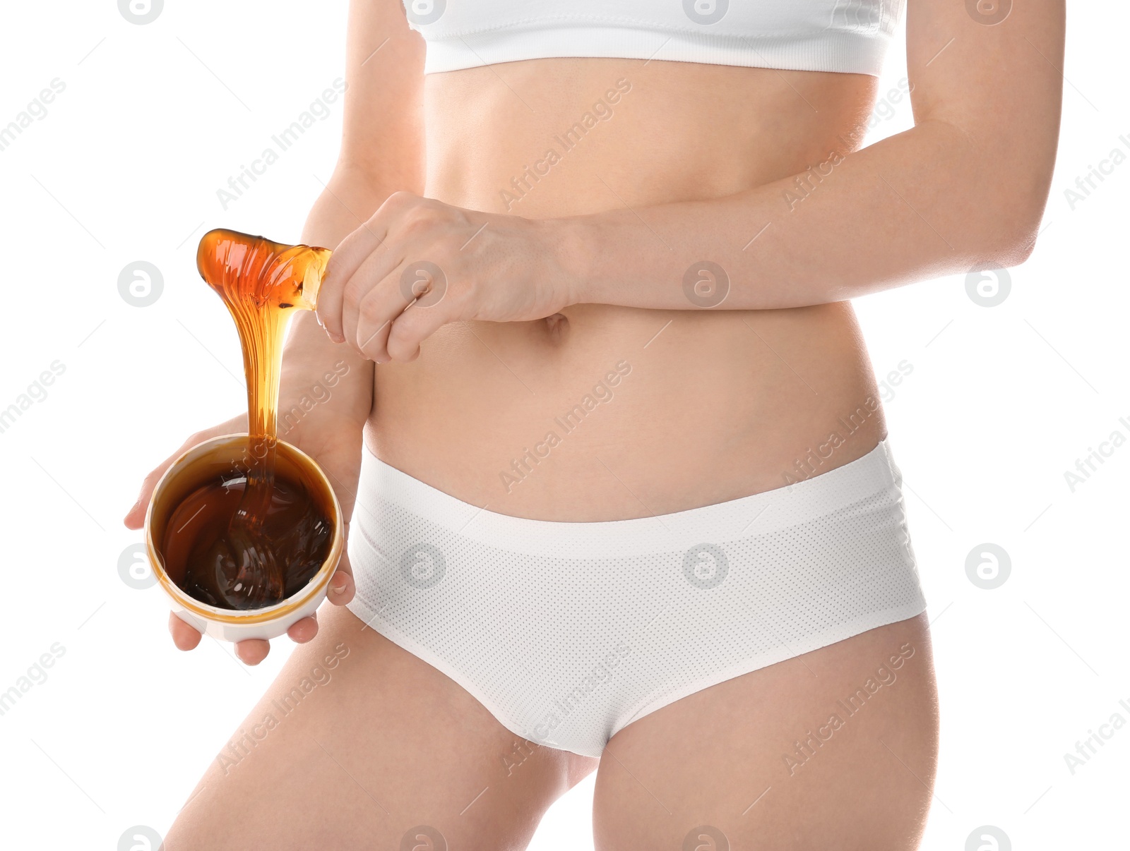 Photo of Young woman holding hot wax on white background, closeup. Epilation procedure