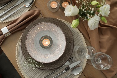 Photo of Festive table setting with beautiful candles and floral decor, flat lay