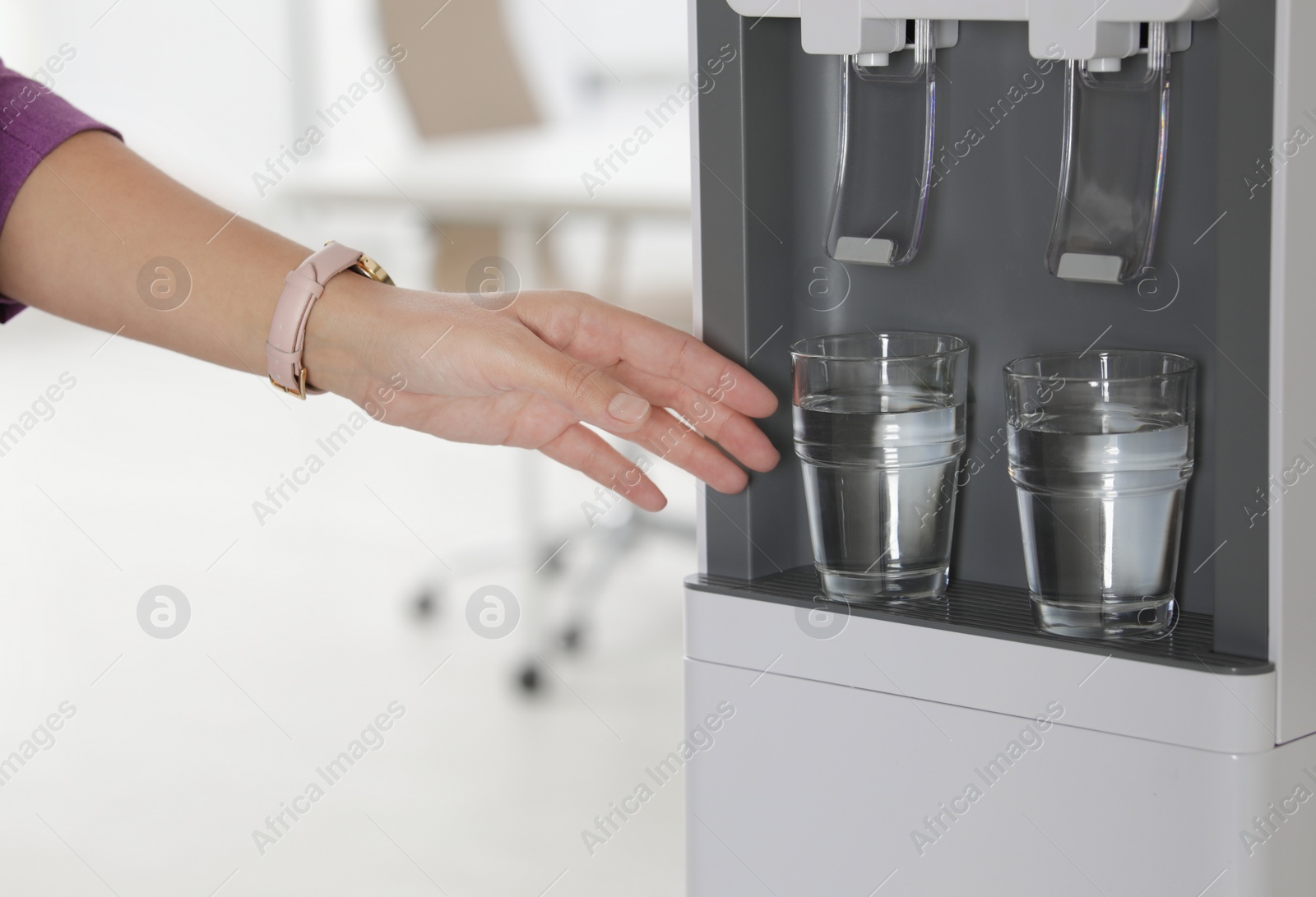 Photo of Woman taking glass of water from cooler in office, closeup