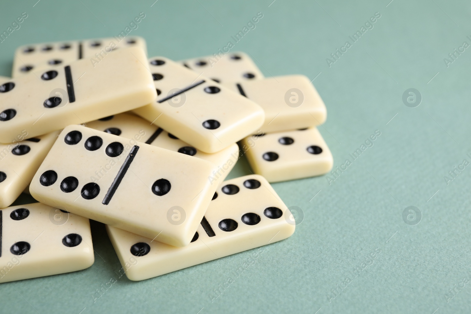 Photo of Classic domino tiles on grey background, closeup. Space for text