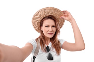 Beautiful woman in straw hat taking selfie on white background