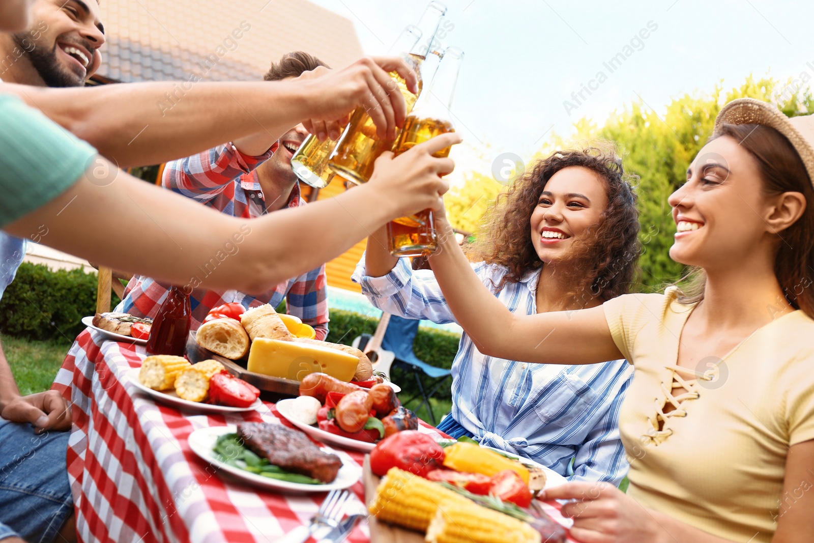 Photo of Happy friends with drinks having fun at barbecue party outdoors