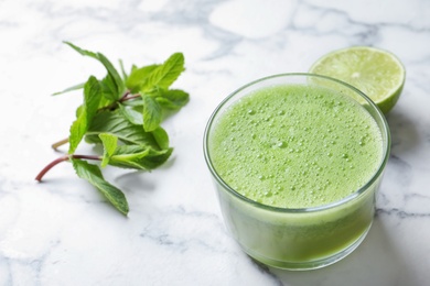 Photo of Glass with delicious detox juice and ingredients on table