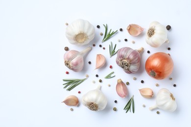 Fresh garlic, onion, rosemary and peppercorns on white background, flat lay. Space for text