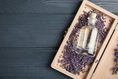 Photo of Flat lay composition with natural herbal oil and lavender flowers on wooden background. Space for text