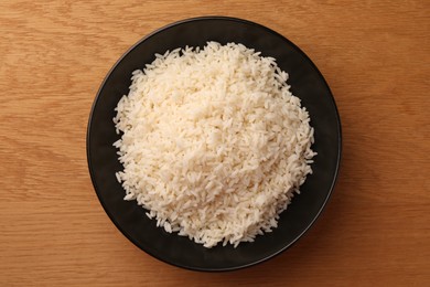 Photo of Plate with delicious rice on wooden table, top view