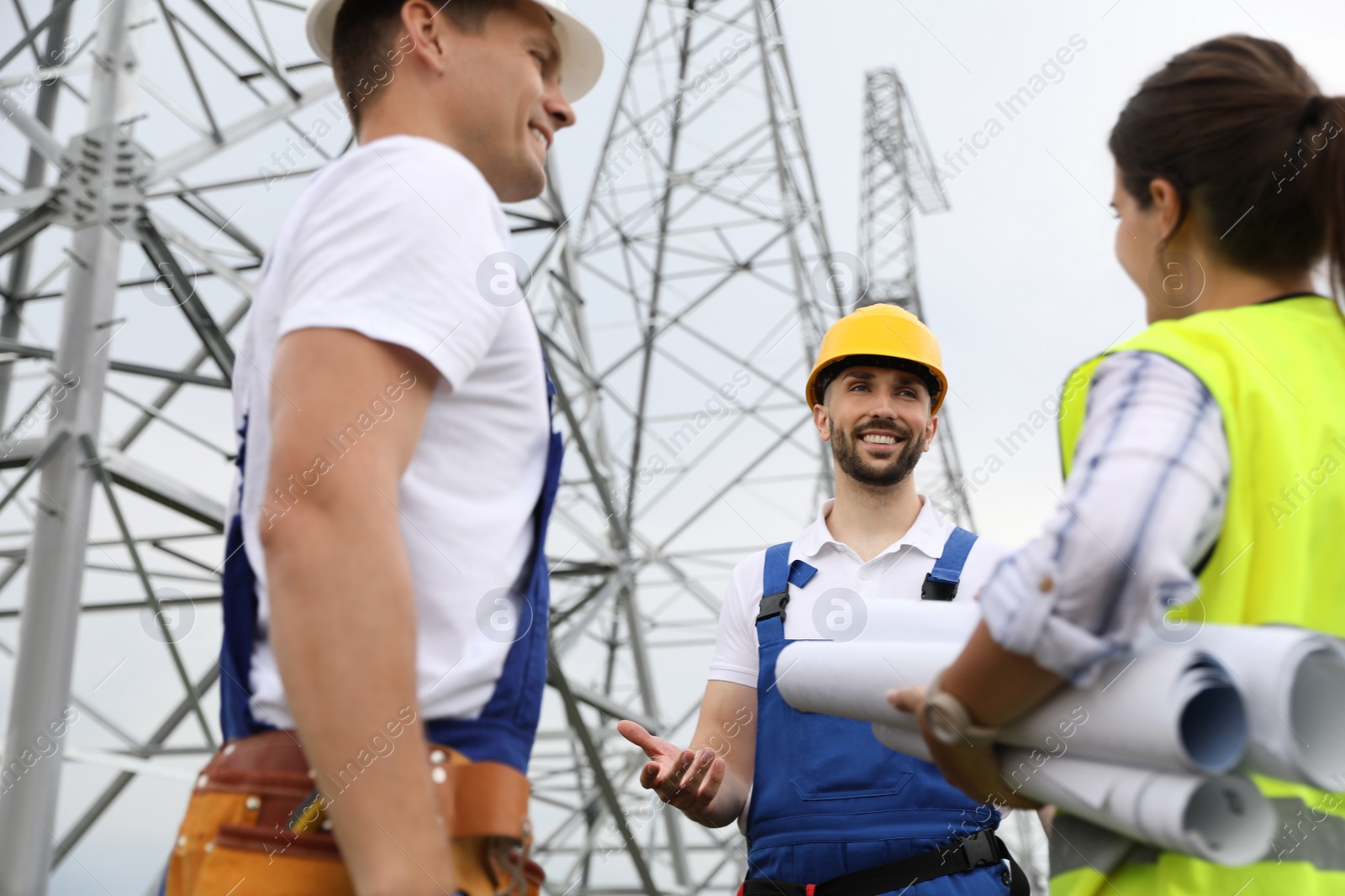 Photo of Professional engineers working on installation of electrical substation outdoors