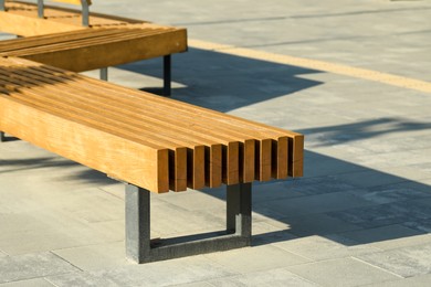Photo of Wooden bench in city on sunny morning
