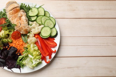 Photo of Balanced diet and healthy foods. Plate with different delicious products on wooden table, top view. Space for text