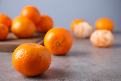 Photo of Fresh ripe tangerine on grey table. Space for text