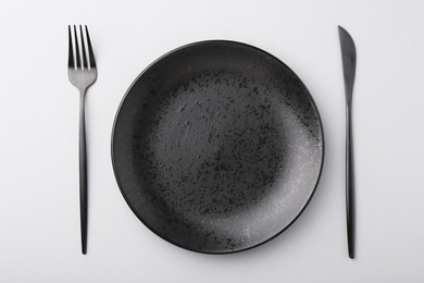 Photo of Setting with stylish cutlery on grey table, top view