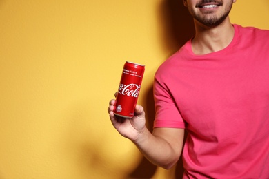 Photo of MYKOLAIV, UKRAINE - NOVEMBER 28, 2018: Young man with Coca-Cola can on color background, space for text