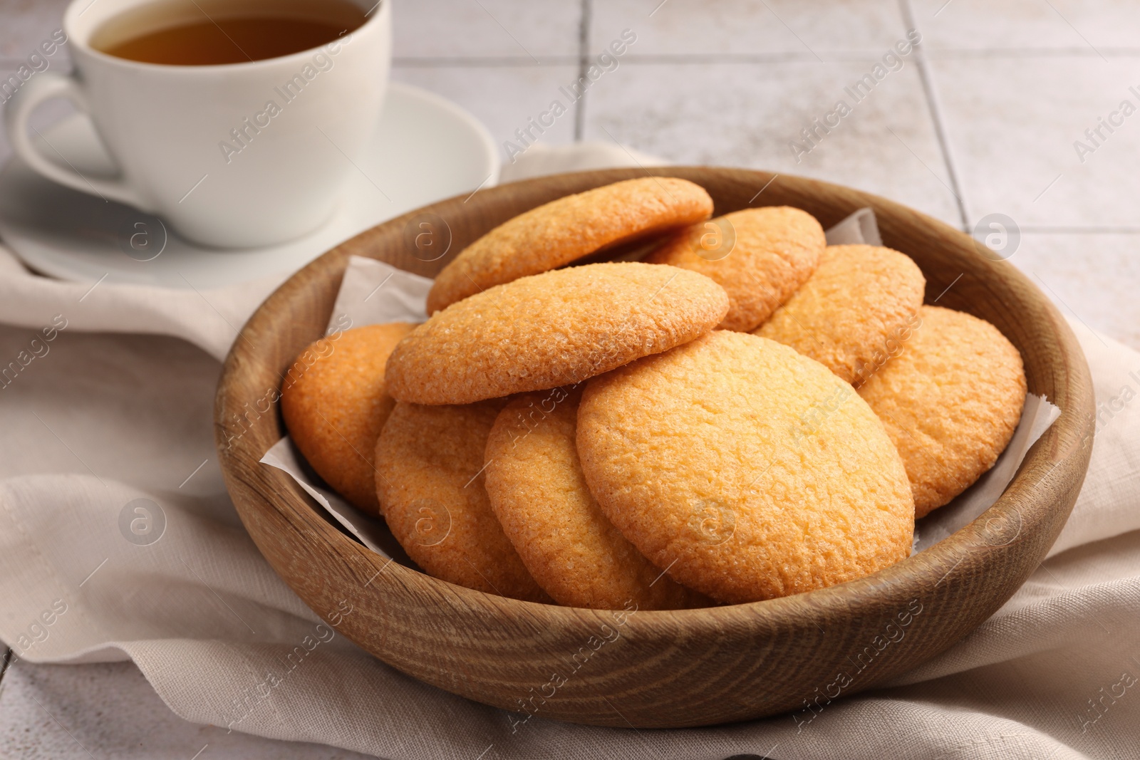 Photo of Delicious Danish butter cookies and tea on white tiled table, closeup