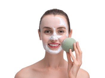 Photo of Happy young woman washing off face mask with sponge on white background