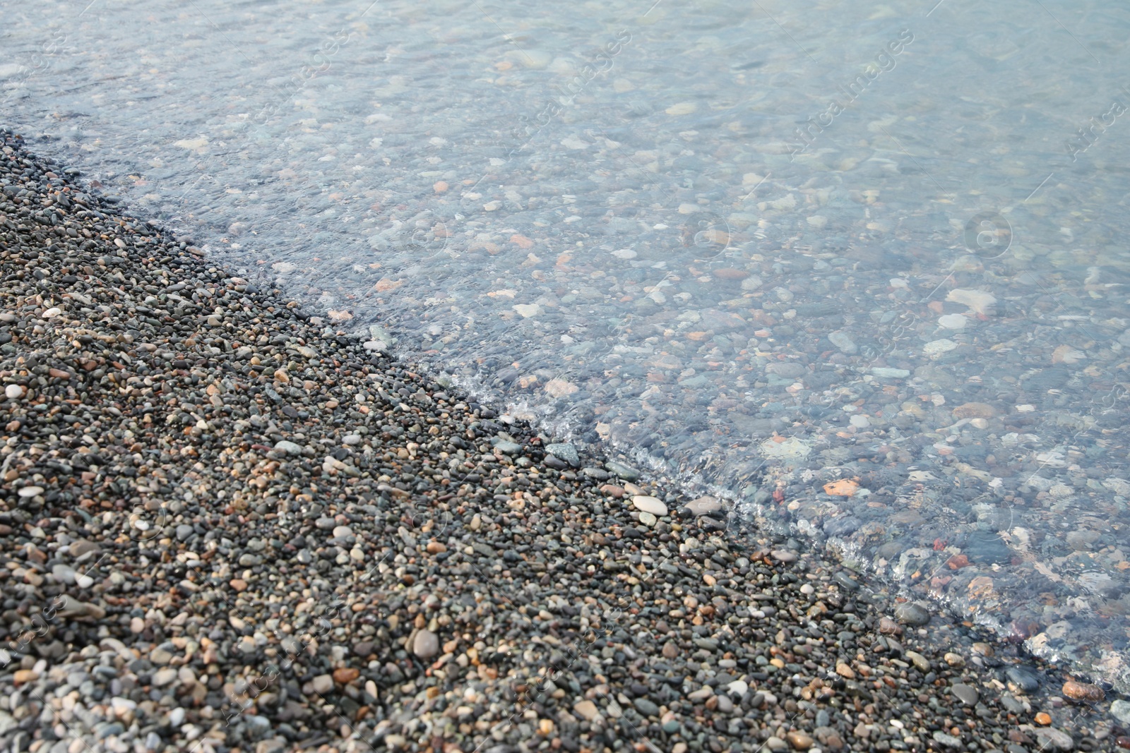 Photo of Beautiful view of sea tide on shingle beach. Summer vacation