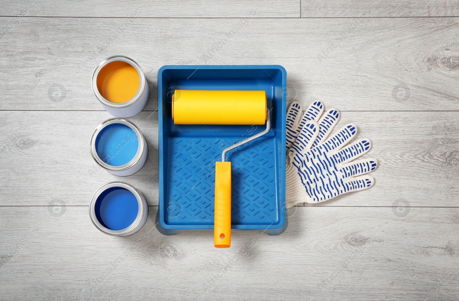 Photo of Flat lay composition with cans of paint and decorator tools on wooden background