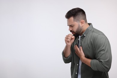 Photo of Sick man coughing on white background, space for text