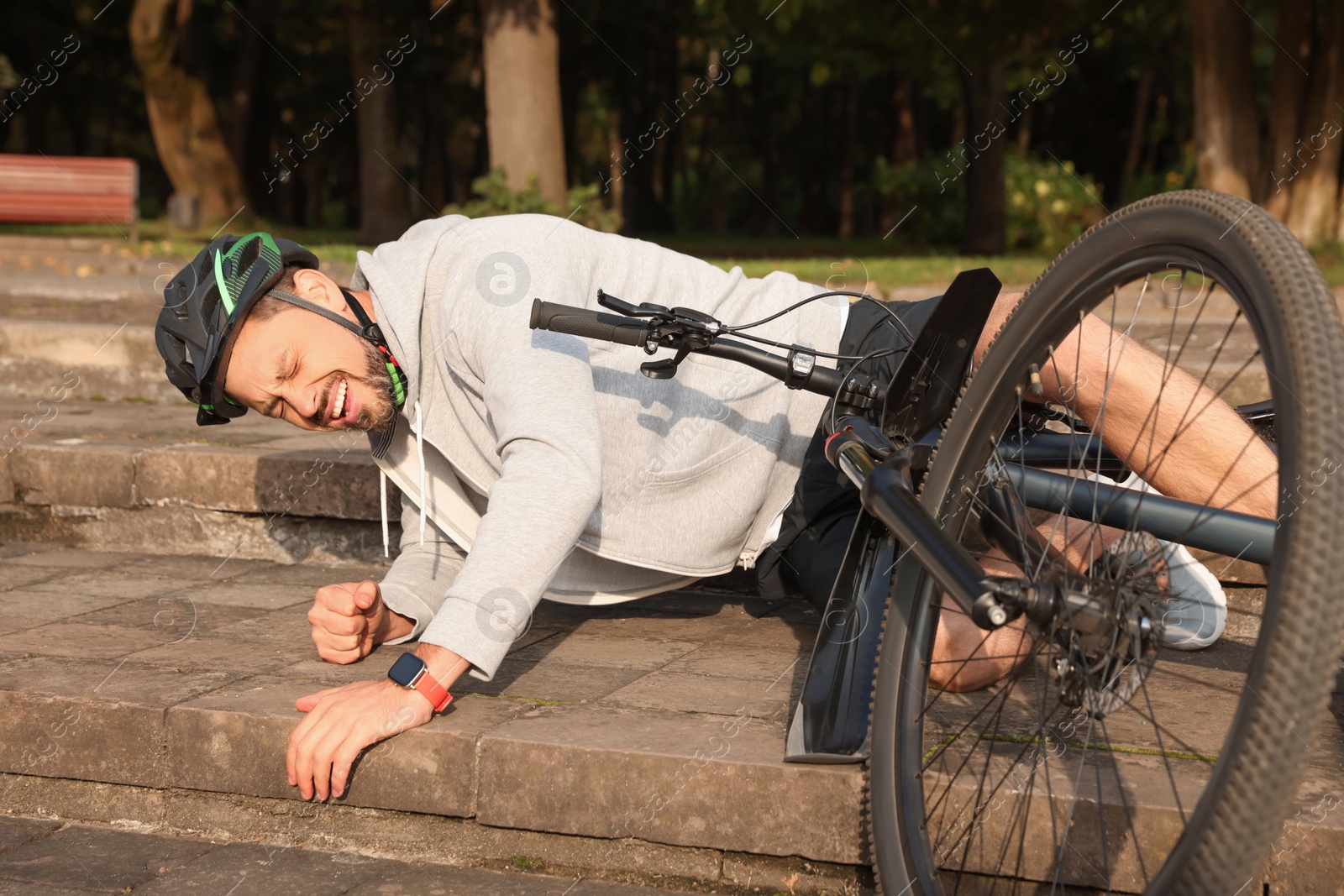 Photo of Man fallen off his bicycle on steps outdoors