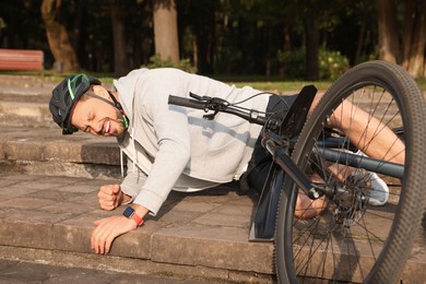 Photo of Man fallen off his bicycle on steps outdoors