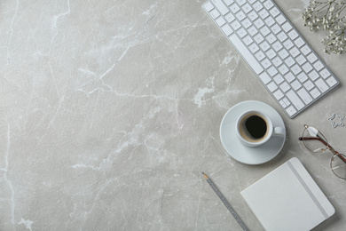 Flat lay composition with keyboard, coffee and stationery on marble table. Space for text