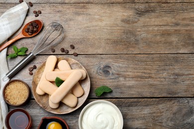 Flat lay composition with tiramisu ingredients on wooden table, space for text