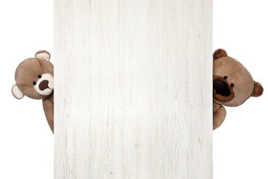 Photo of Cute teddy bears peeking out of wooden board on white background
