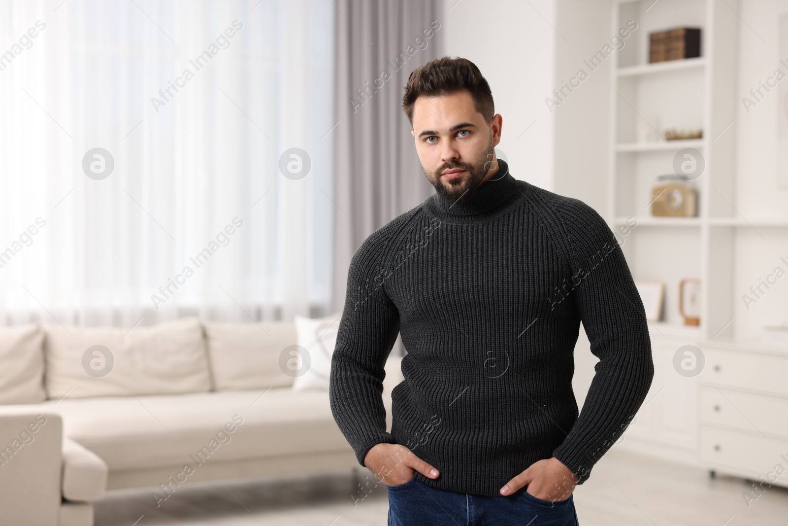Photo of Handsome man in stylish sweater at home, space for text
