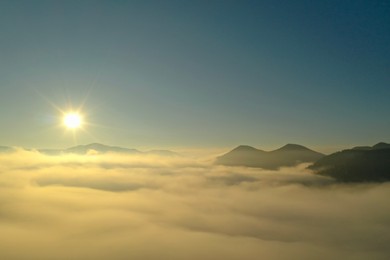 Sun shining over misty mountains. Drone photography