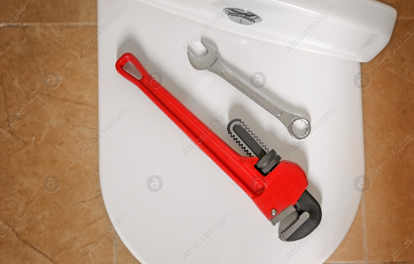 Photo of Different plumber's tools on toilet seat lid indoors