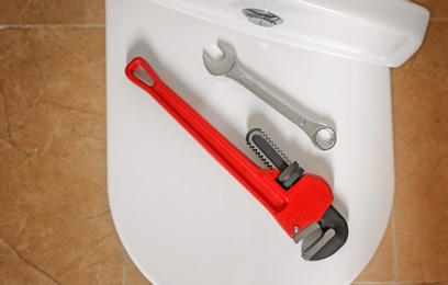 Photo of Different plumber's tools on toilet seat lid indoors