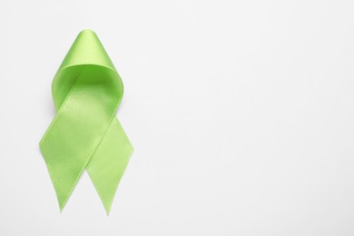 World Mental Health Day. Green ribbon on white background, top view with space for text