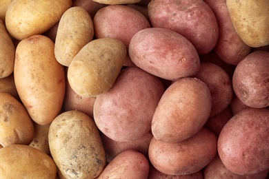 Photo of Fresh ripe organic potatoes as background, top view