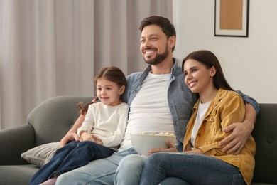 Photo of Happy family watching TV on sofa at home