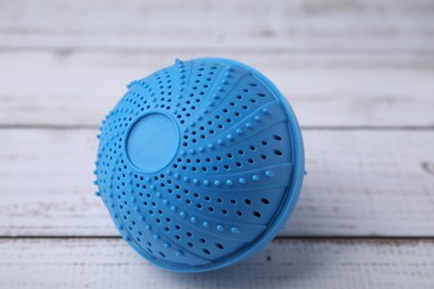 Dryer ball for washing machine on white wooden table, closeup