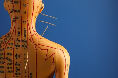 Photo of Acupuncture - alternative medicine. Human model with needles in head and shoulder on blue background, space for text