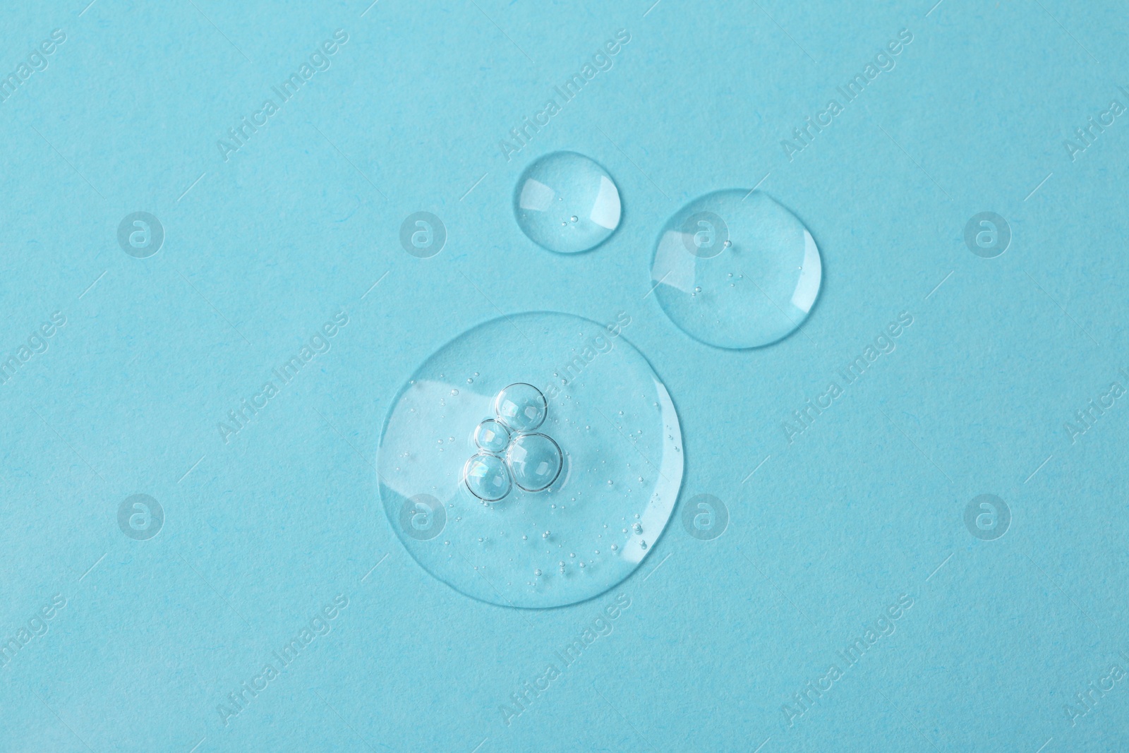 Photo of Samples of cosmetic serum on light blue background, flat lay
