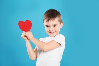 Photo of Portrait of boy with paper heart on color background