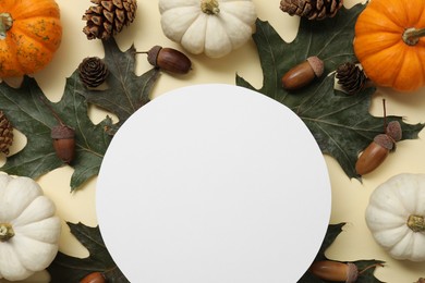 Photo of Thanksgiving day. Flat lay composition with pumpkins and blank card on beige background, space for text