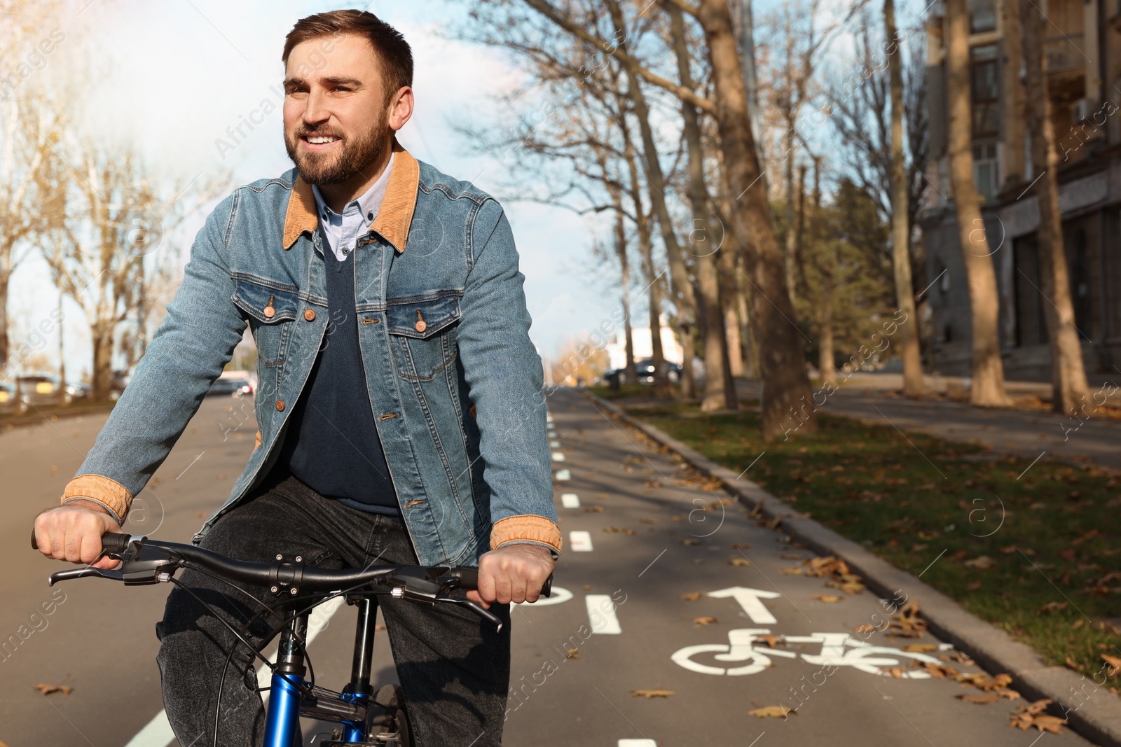 Photo of Happy handsome man riding bicycle on lane in city