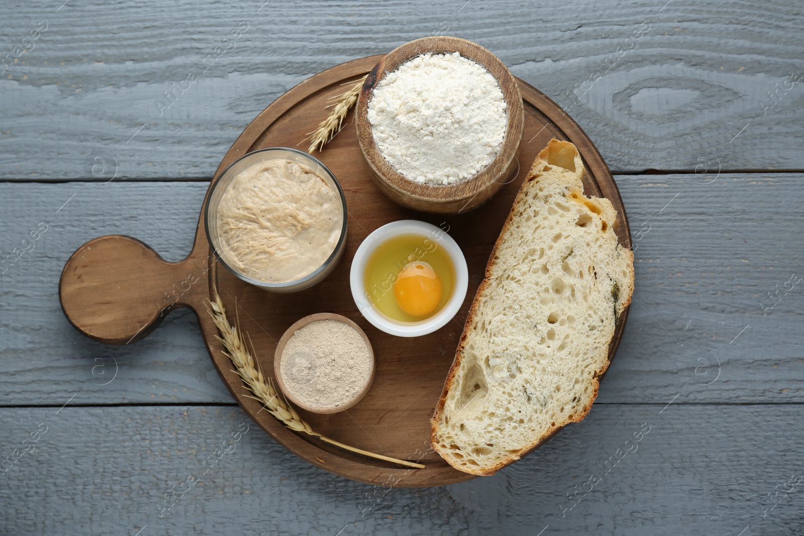 Photo of Slice of bread and ingredients on grey wooden table, top view