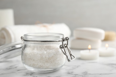 Jar of aromatic salt on marble table. Space for text
