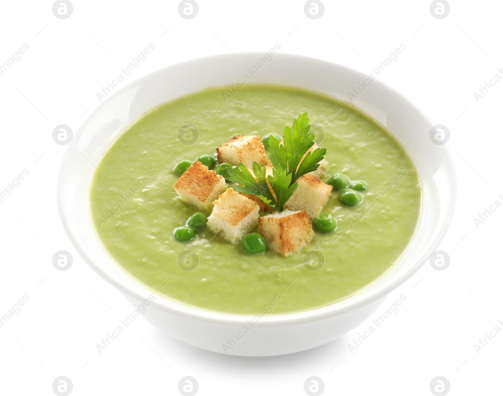 Photo of Fresh vegetable detox soup made of green peas with croutons in dish on white background