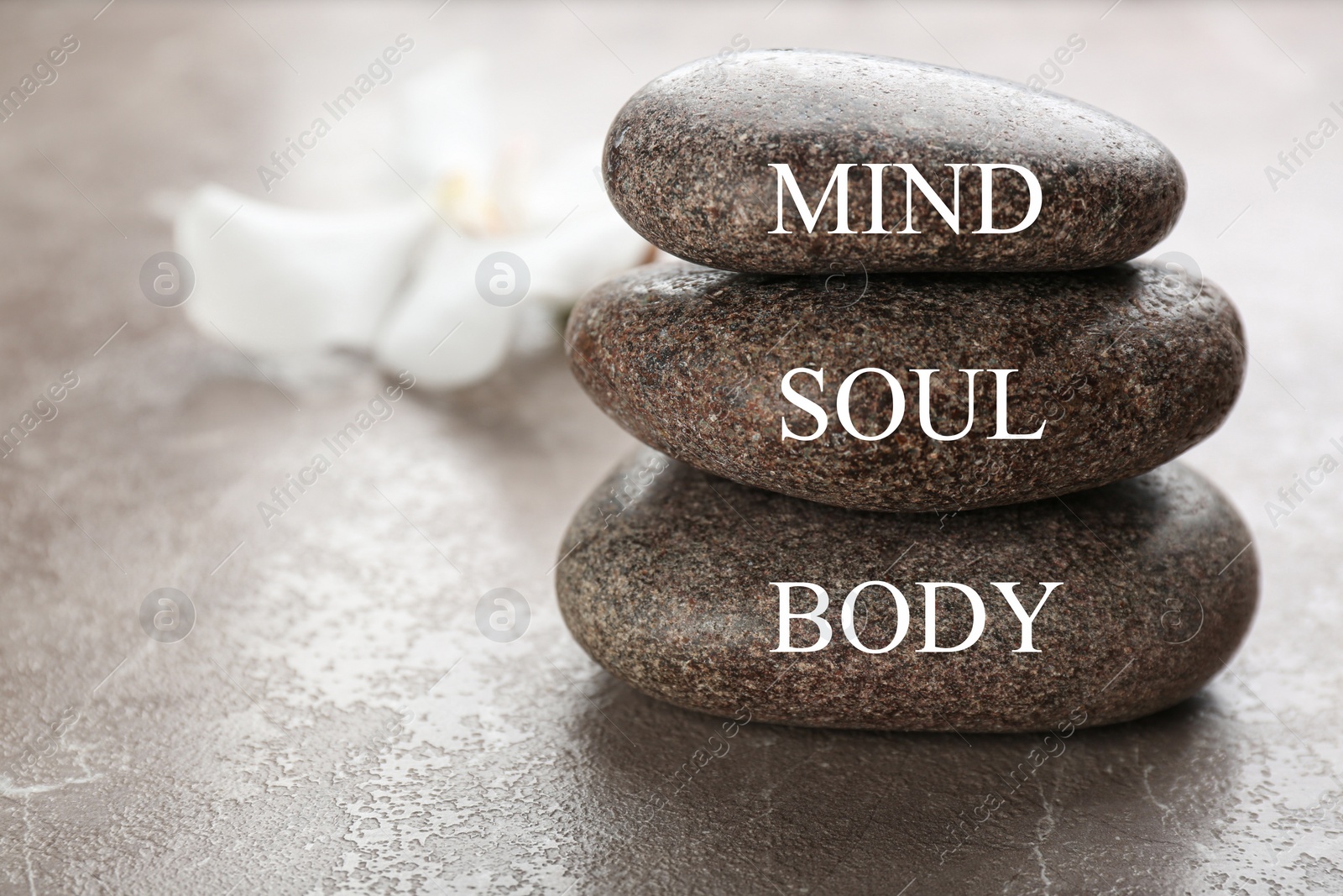 Photo of Stones with words MIND, BODY, SOUL on brown marble background, space for text. Zen lifestyle