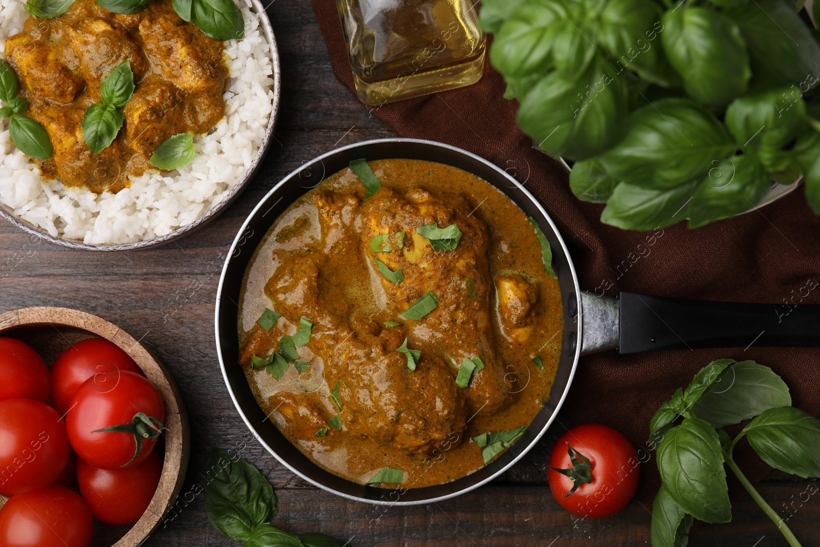 Photo of Delicious rice and chicken with curry sauce served on wooden table, flat lay