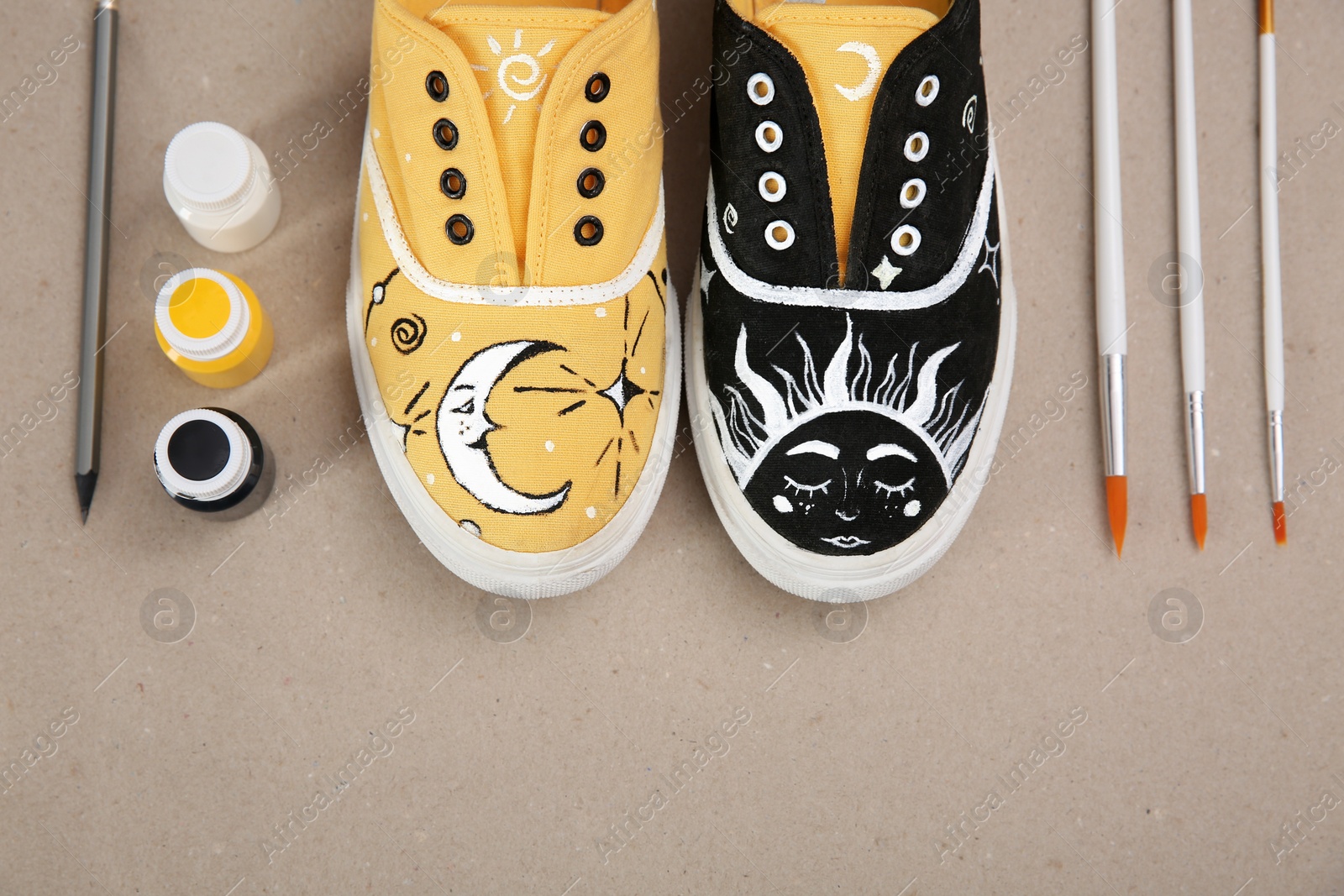 Photo of Amazing customized shoes and painting supplies on beige background, flat lay