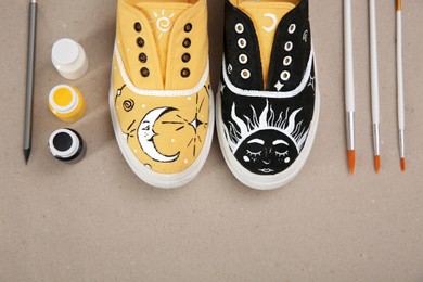 Photo of Amazing customized shoes and painting supplies on beige background, flat lay